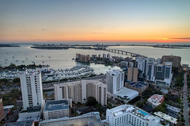 aerial view at dusk featuring a water view