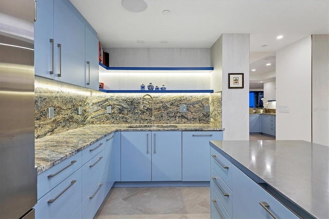 1255 N Gulfstream Ave Unit Ph1501, Sarasota, FL 34236 - kitchen featuring a sink, tasteful backsplash, stainless steel refrigerator, light stone counters, and blue cabinets