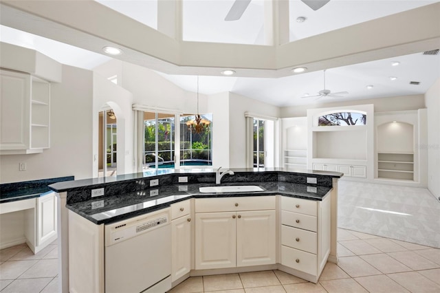 kitchen with dishwasher, a kitchen island with sink, dark stone counters, and built in shelves