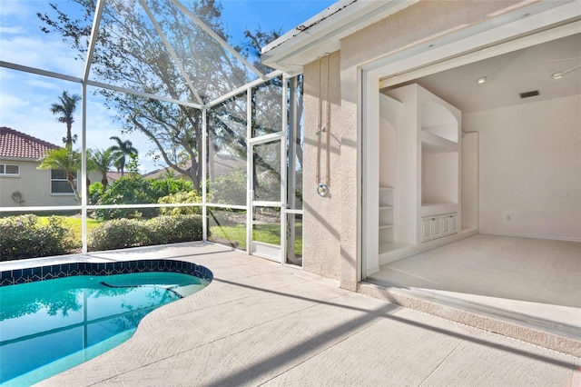 view of swimming pool with glass enclosure and a patio area