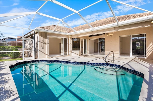 view of pool featuring a patio, glass enclosure, and ceiling fan