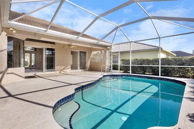 view of swimming pool featuring a patio area, ceiling fan, french doors, and glass enclosure