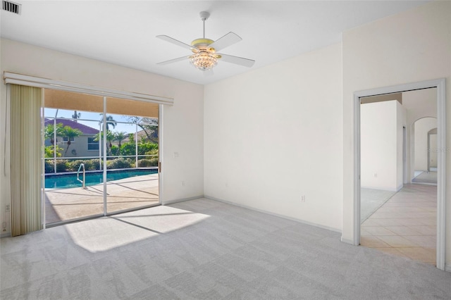 carpeted spare room with ceiling fan