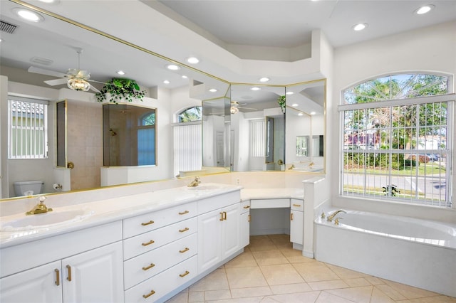 bathroom featuring tile patterned flooring, ceiling fan, tiled shower, and vanity