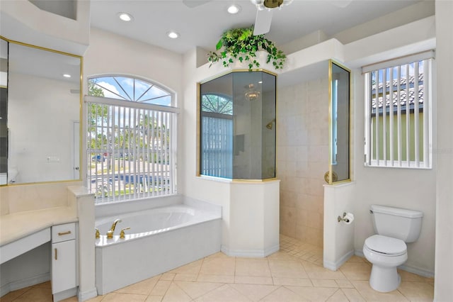 full bathroom with tile patterned floors, vanity, ceiling fan, shower with separate bathtub, and toilet