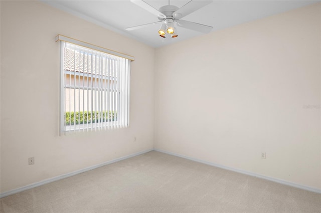 carpeted spare room featuring ceiling fan