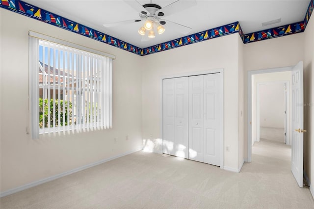 unfurnished bedroom with a closet, ceiling fan, and light colored carpet