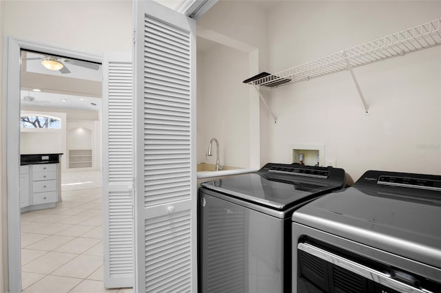 clothes washing area featuring washing machine and dryer, sink, and light tile patterned floors