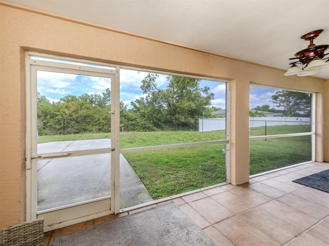 unfurnished sunroom featuring ceiling fan