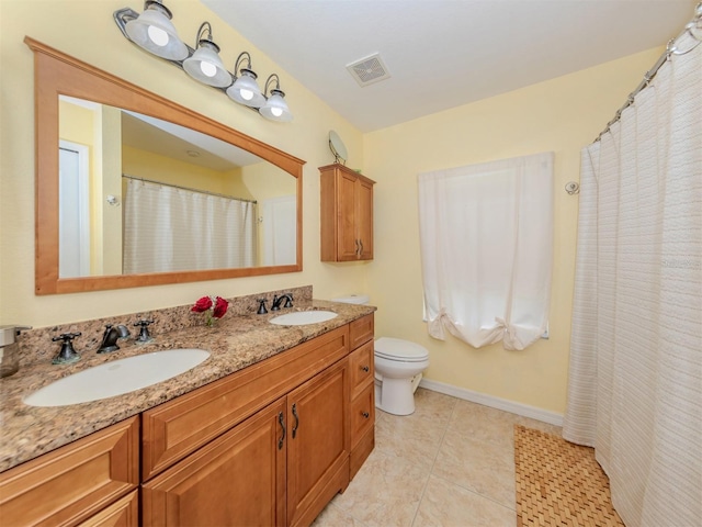 bathroom featuring tile patterned floors, vanity, and toilet