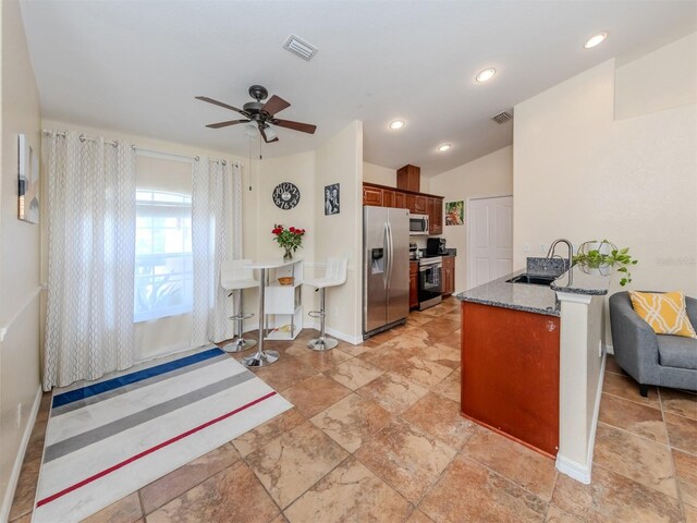 kitchen featuring kitchen peninsula, ceiling fan, sink, and appliances with stainless steel finishes