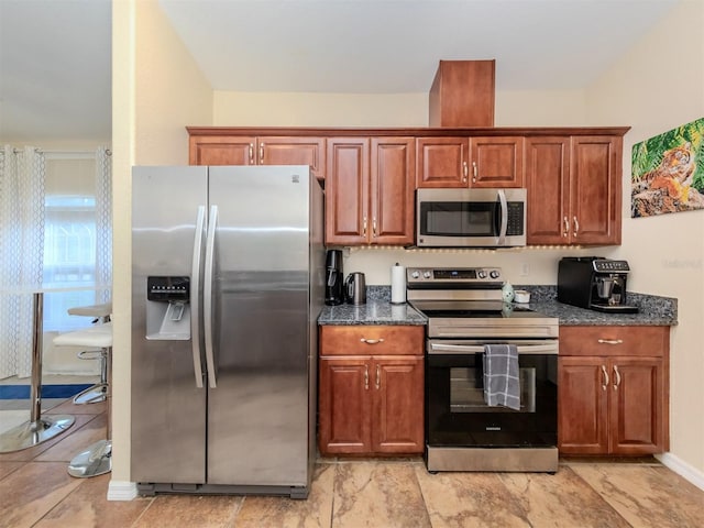 kitchen with stainless steel appliances and dark stone counters