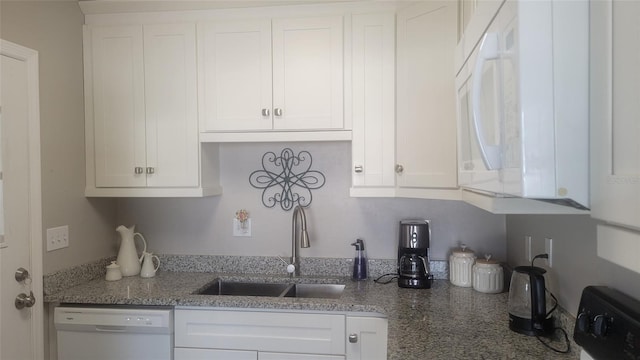 kitchen featuring white cabinets, stone counters, sink, and white dishwasher