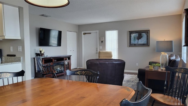 dining room featuring a fireplace and a textured ceiling