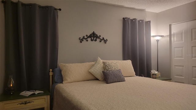 bedroom with a textured ceiling and a closet