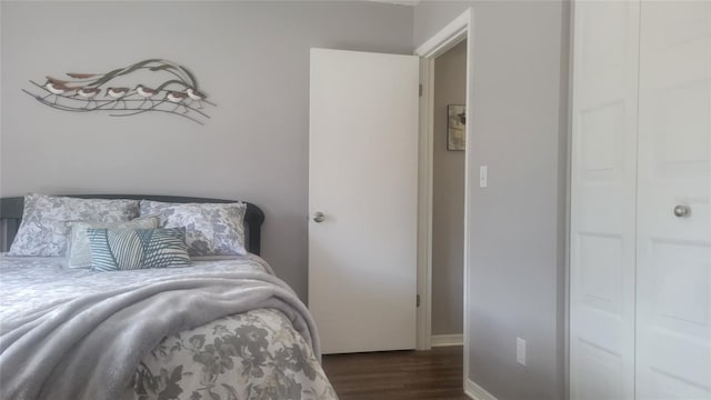 bedroom with dark hardwood / wood-style flooring and a closet