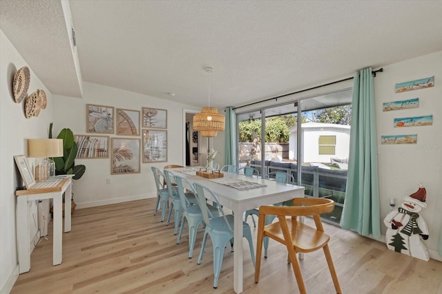 dining room with a textured ceiling and light wood-type flooring