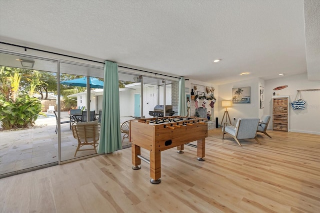 playroom featuring light hardwood / wood-style flooring and a textured ceiling