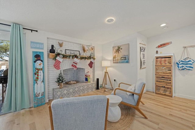 living area featuring hardwood / wood-style flooring, a fireplace, and a textured ceiling