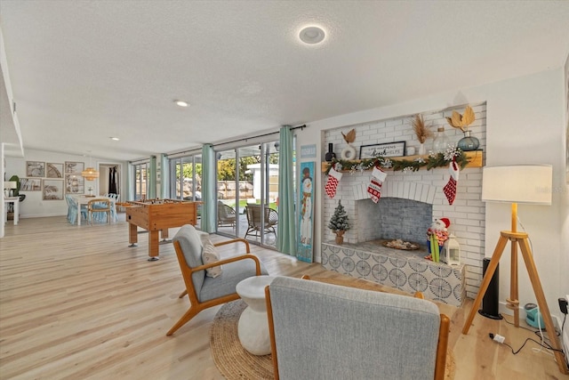 interior space with a brick fireplace, hardwood / wood-style flooring, and a textured ceiling