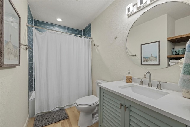 full bathroom with shower / bathtub combination with curtain, hardwood / wood-style flooring, vanity, a textured ceiling, and toilet