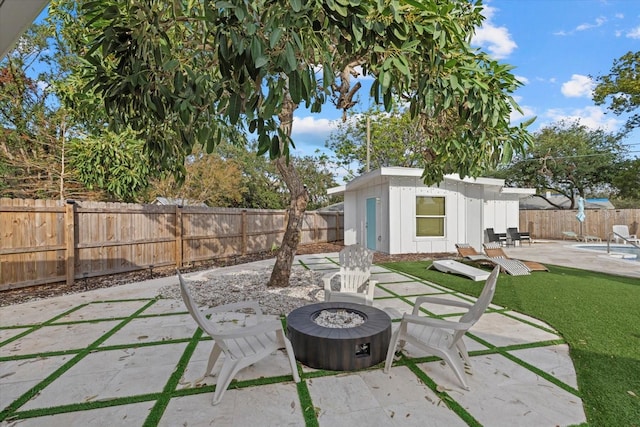 view of patio featuring an outbuilding and an outdoor fire pit