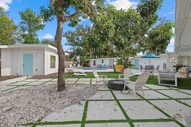 view of patio featuring an outdoor structure and a fire pit