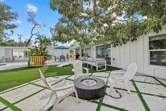 view of patio with an outdoor living space with a fire pit