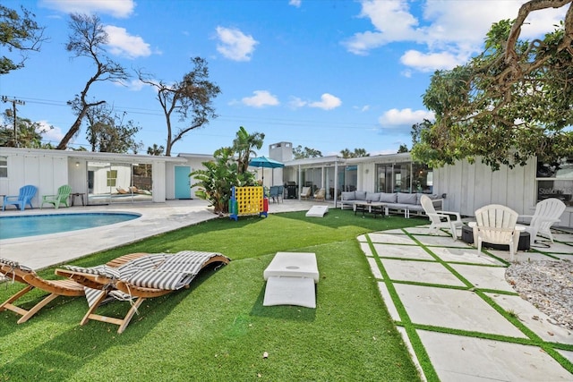 rear view of property with a yard, outdoor lounge area, and a patio