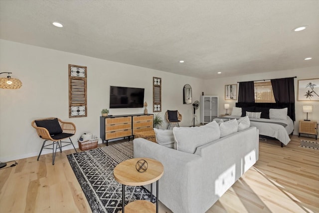 living room with a textured ceiling and light wood-type flooring