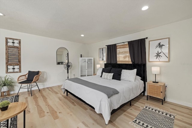 bedroom with light hardwood / wood-style floors and a textured ceiling