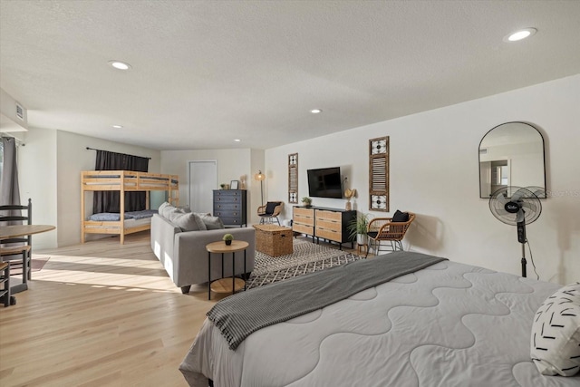 bedroom with a textured ceiling and light wood-type flooring