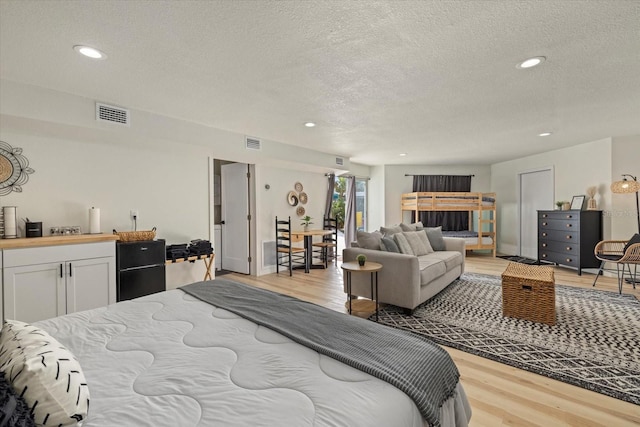 bedroom featuring light hardwood / wood-style flooring and a textured ceiling