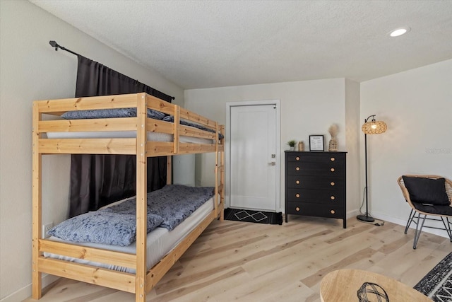 bedroom with hardwood / wood-style floors and a textured ceiling