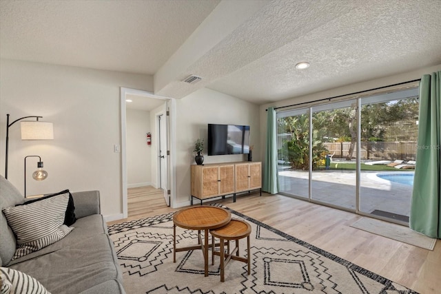 living room featuring a textured ceiling and light hardwood / wood-style floors