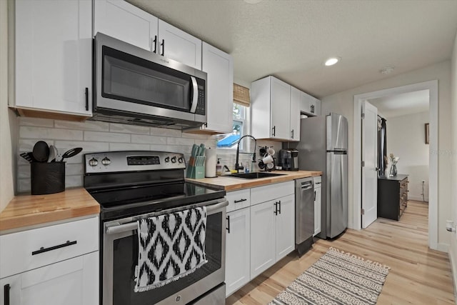 kitchen featuring white cabinetry, stainless steel appliances, and sink