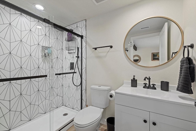 bathroom featuring vanity, a shower with door, and toilet