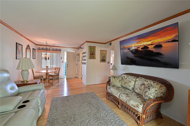 living room featuring wood-type flooring, ornamental molding, and a chandelier