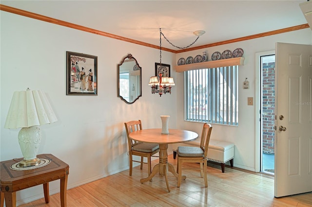 dining space with a chandelier, light hardwood / wood-style floors, and ornamental molding