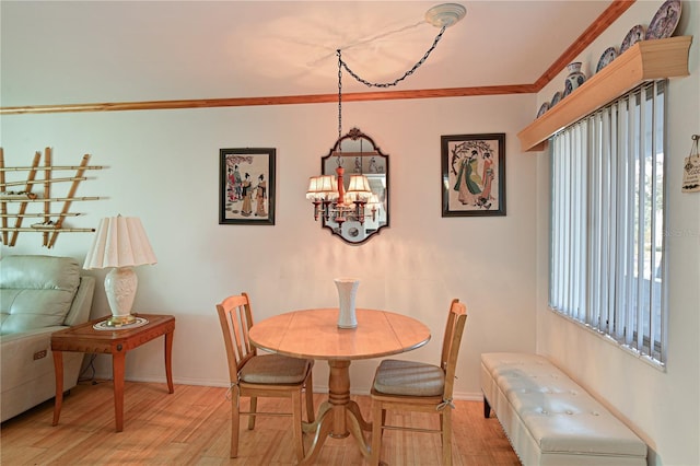 dining area featuring light hardwood / wood-style flooring, a chandelier, and ornamental molding