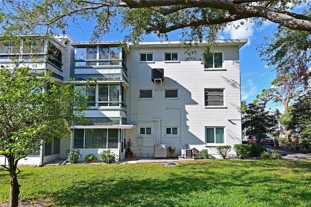 rear view of house featuring a lawn and cooling unit