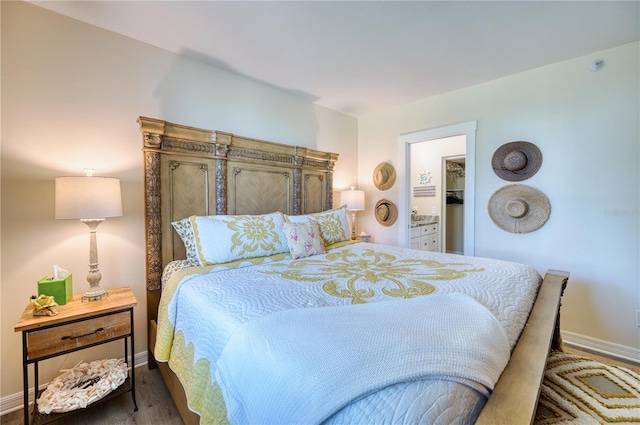 bedroom with a walk in closet and dark wood-type flooring