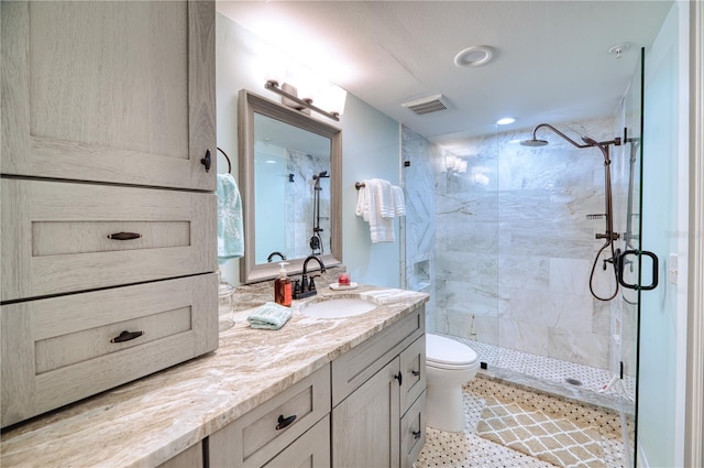 bathroom with vanity, toilet, and a shower with shower door