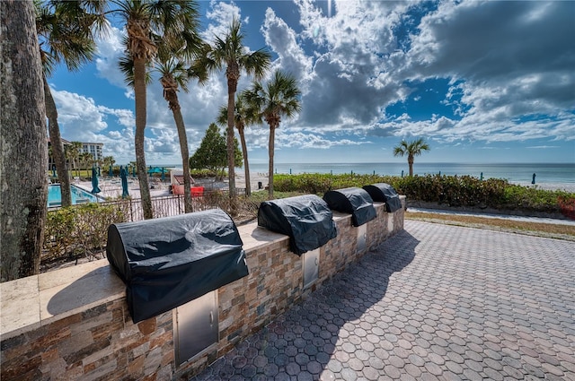 view of patio with a water view, area for grilling, and grilling area