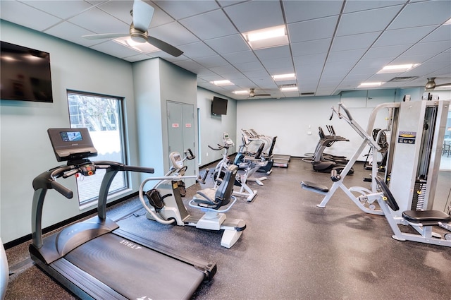 gym with a paneled ceiling and ceiling fan