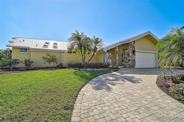 single story home featuring a garage and a front lawn