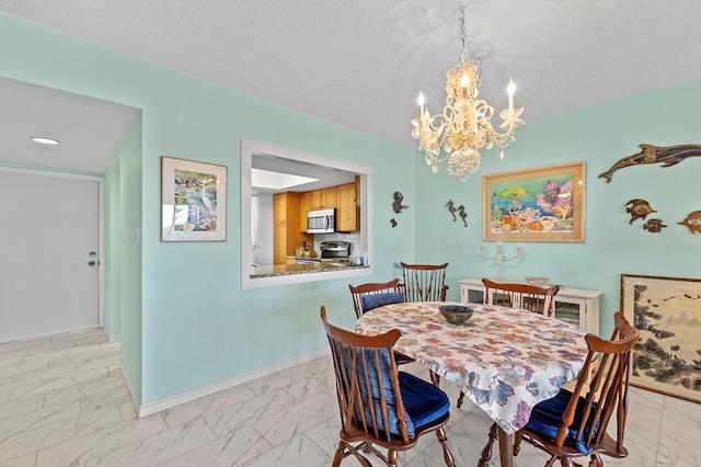 dining area with a textured ceiling and an inviting chandelier