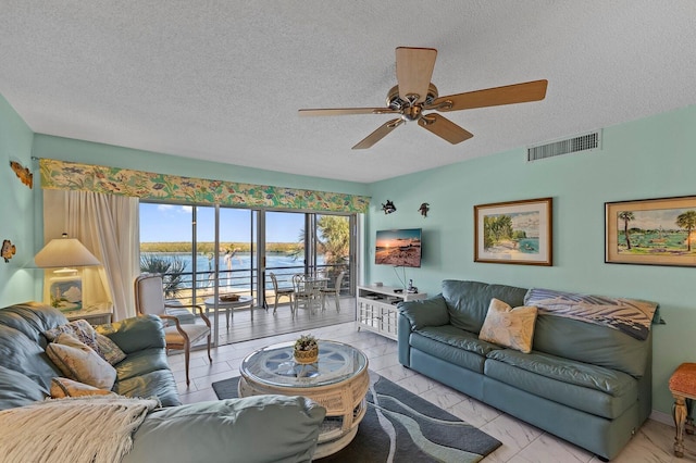 tiled living room featuring ceiling fan and a textured ceiling