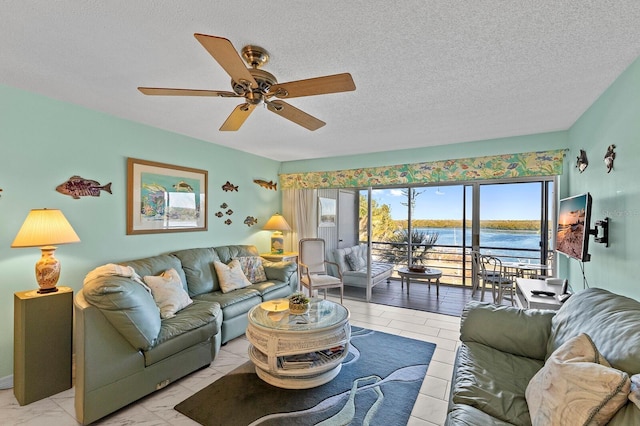 living room featuring ceiling fan and a textured ceiling