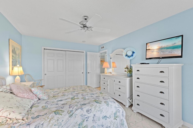 bedroom with a textured ceiling, a closet, and ceiling fan